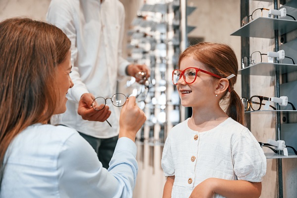 Bambina prova degli occhiali da vista.